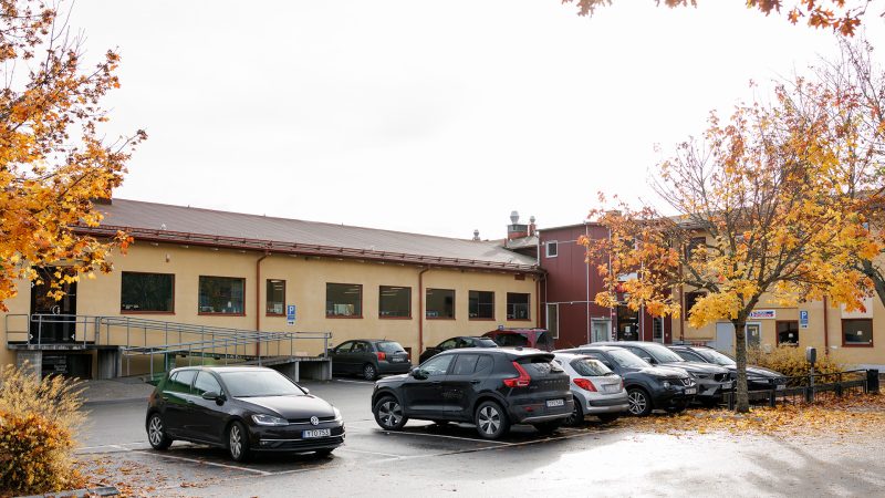 Bilden visar gården med parkeringsplatser framför kontoret.