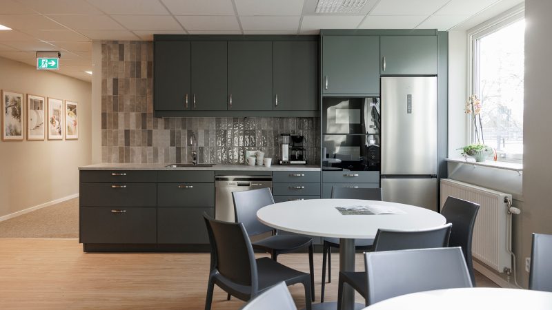 Bilden visar det nya moderna köket i i varma färger.